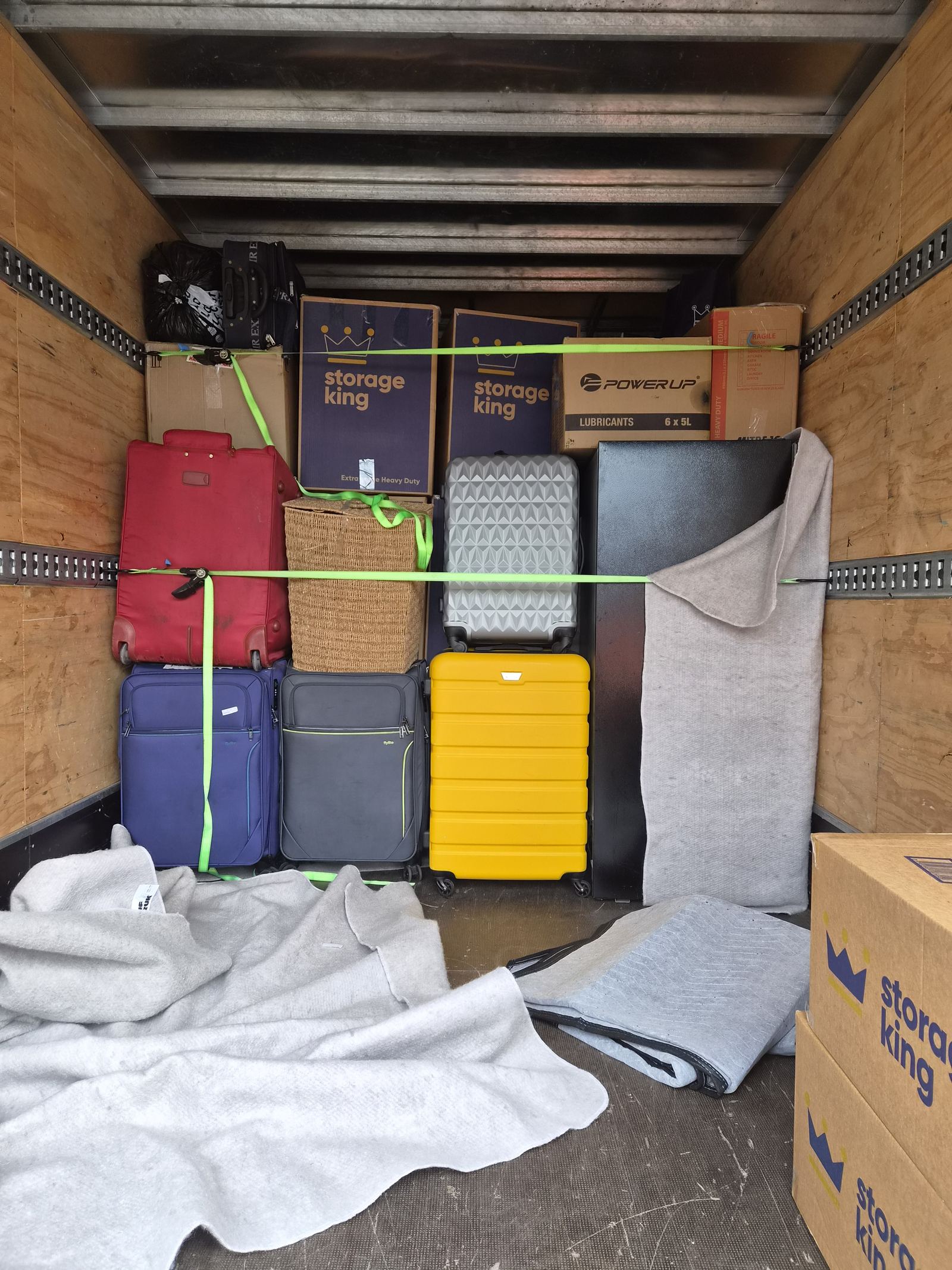 Suitcases and boxes blanket-padded and strapped down inside the First Light Movers truck
