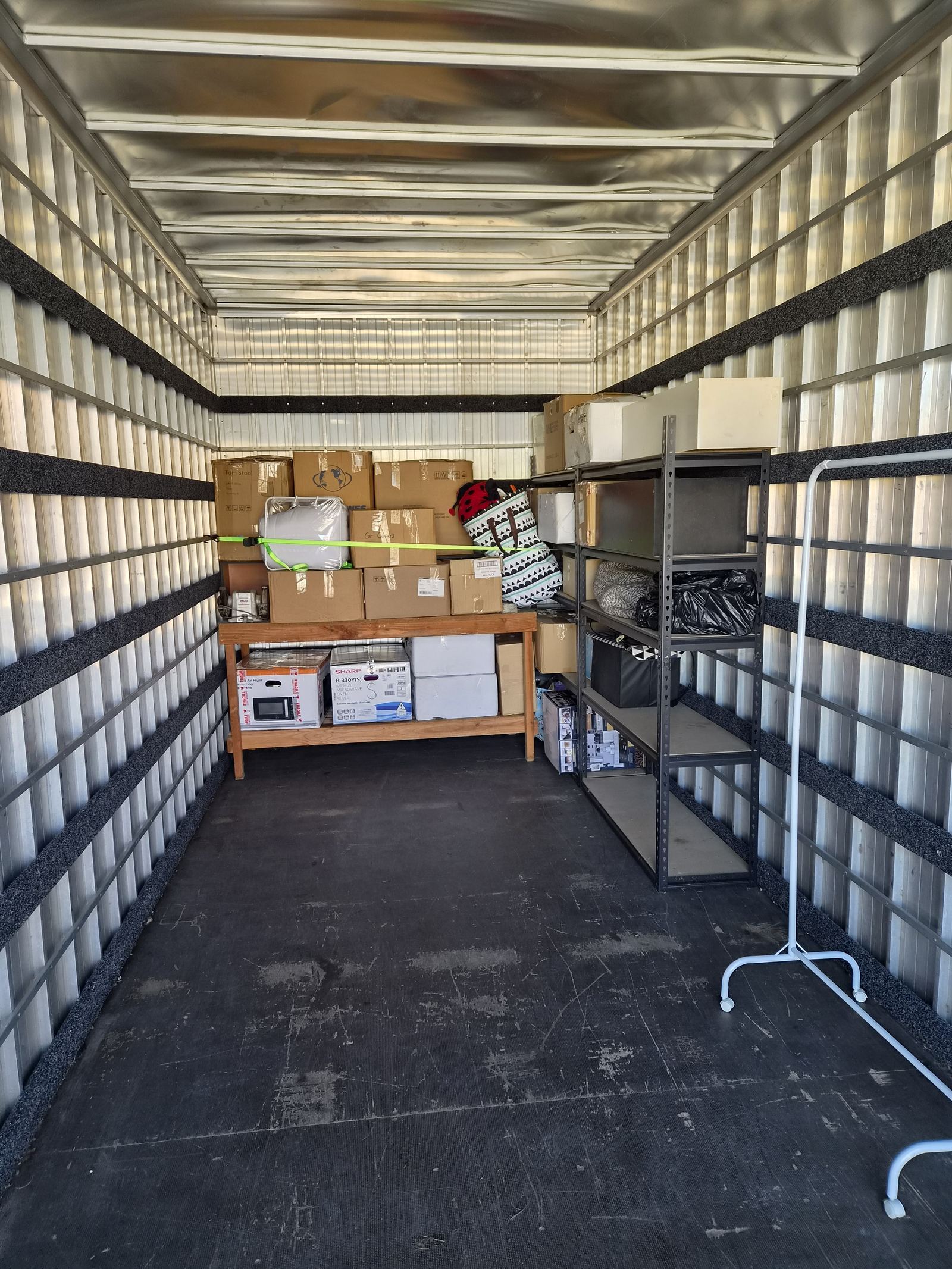Boxes, appliances and shelving neatly organised and secured inside the First Light Movers truck